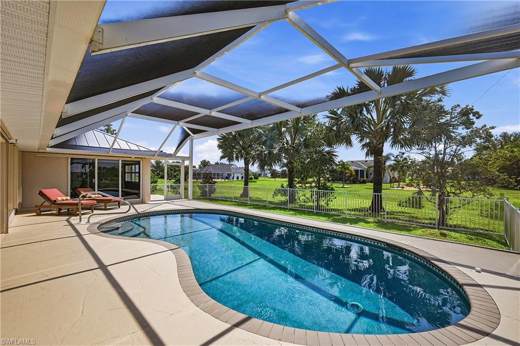 Resort-Style Lanai with Heated Swimming Pool and Retractable Storm-Smart Shade SystemThis expansive covered lanai showcases a resort-inspired outdoor living space anchored by a lagoon-shaped heated swimming pool with tanning ledge
