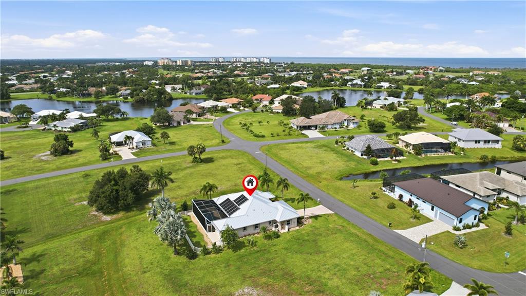 Sprawling property featuring a modern residence with a silver metal roof situated on manicured grounds surrounded by expansive greenspace.