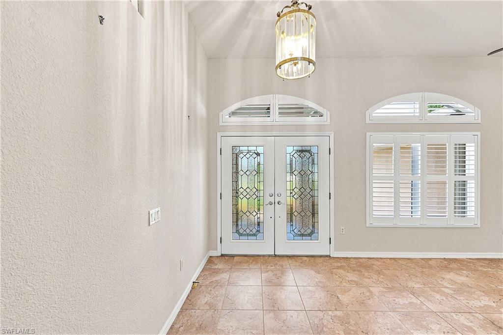 Double entry doors with decorative glass panels and an arched transom window
