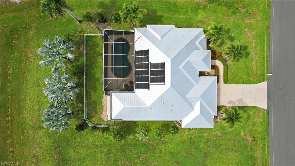 Modern residence showcasing a striking angular roofline with multiple pitched sections, expansive solar panel array across the roof, and clean exterior finishes