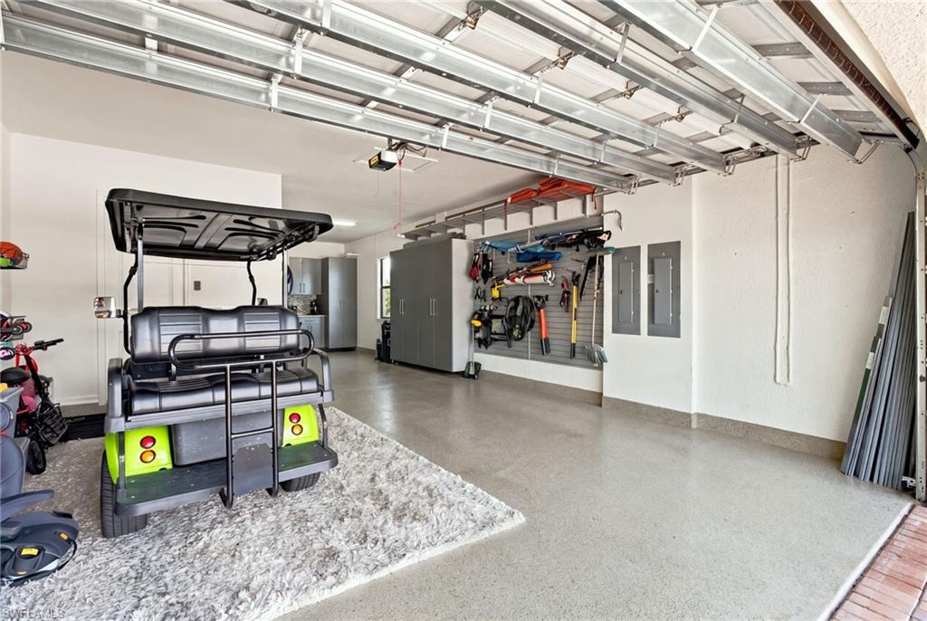 Epoxy-coated 3 car tandem garage with built-in wall organization, overhead garage door opener, and steel storage cabinets