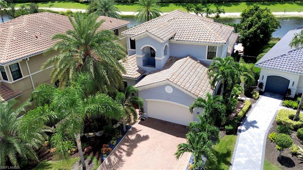 Two-story residence featuring a tile roof, arched entryway, and integrated 3 car tandem garage,