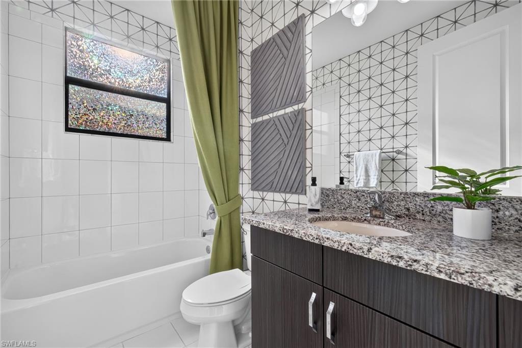3rd bathroom. Integrated tub and shower with white tile surround