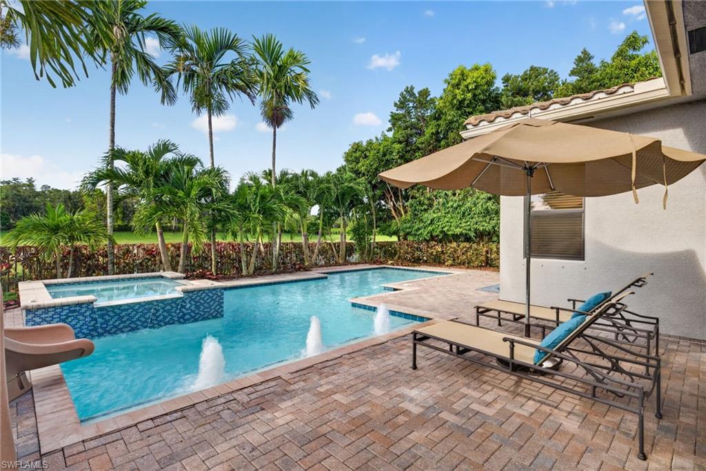 Salt water gas-heated Pool with integrated spa, paver patio, water features, and surrounding tropical landscaping