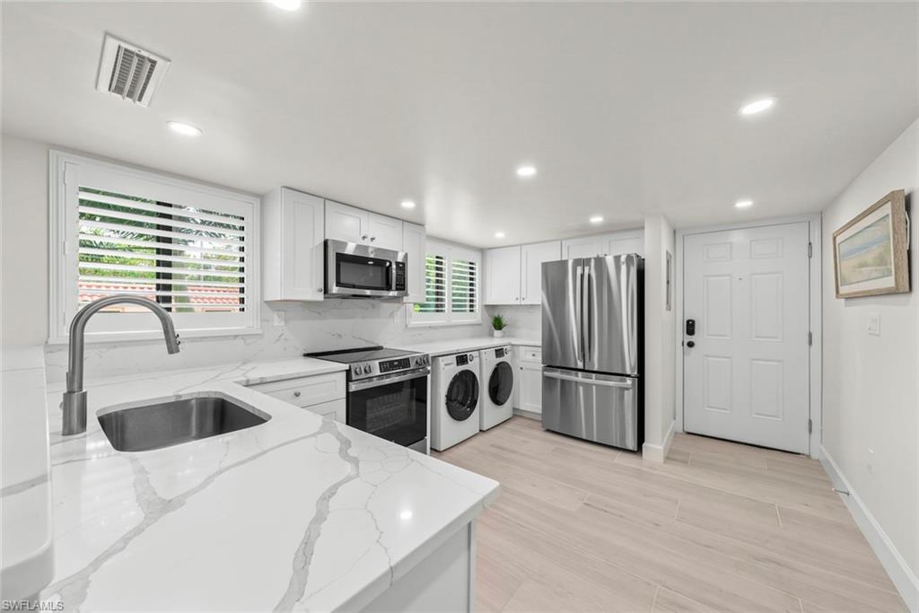 Modern kitchen featuring white shaker cabinetry, stainless steel appliances, white patterned countertops, a stainless steel undermount sink with a gooseneck faucet, and light wood-finish flooring