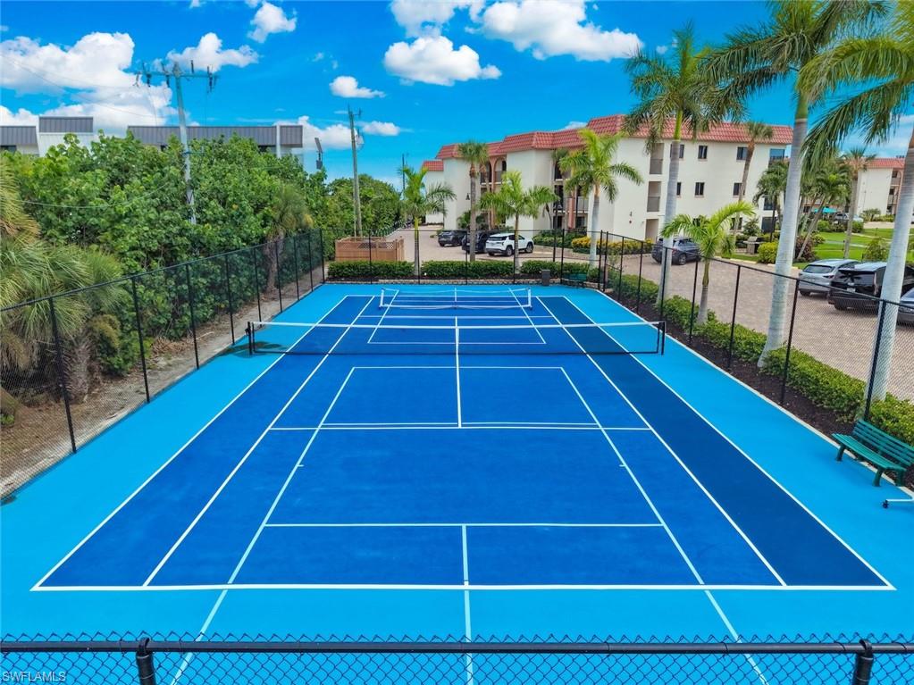 Full-size tennis court featuring a two-tone blue surface with white line markings