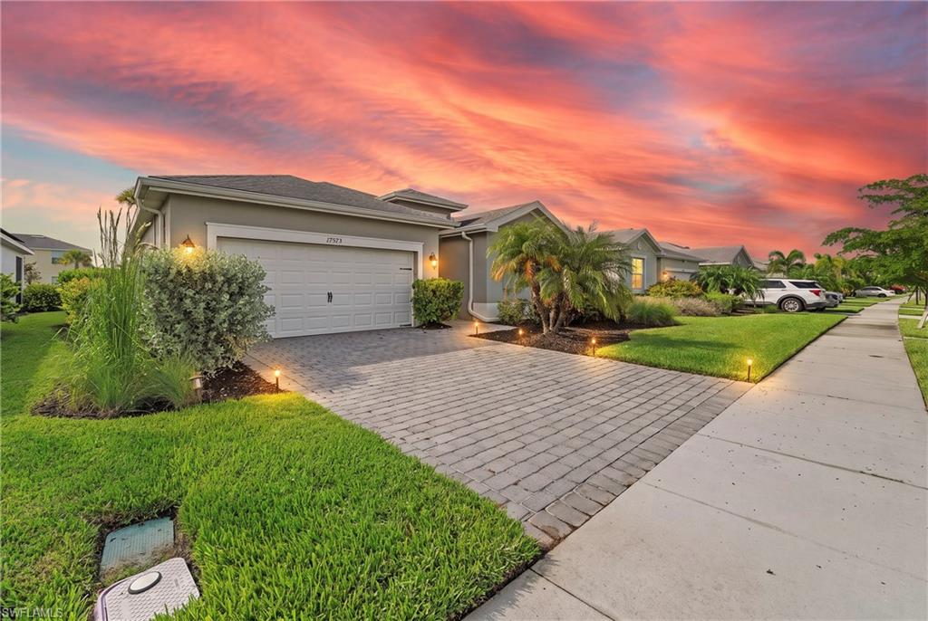 Contemporary single-story residence with a two-car garage, paver driveway, and established landscape lighting
