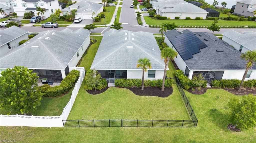 Crown molding and a private window.10. Backyard aerial — Aerial view of the fenced backyard with a screened lanai, mature landscaping, and combined aluminum and vinyl privacy fencing.