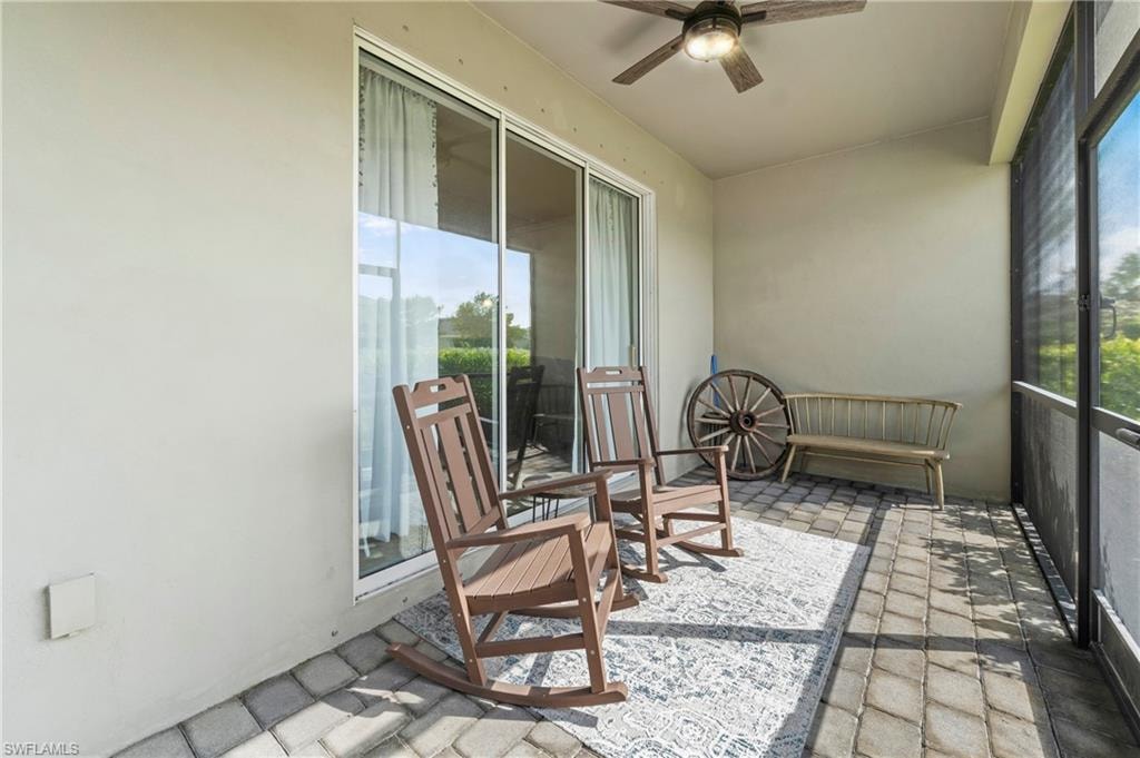 Covered, under-truss screened lanai with paver flooring, a ceiling fan, and sliding glass door access to the living area. Private outdoor living space.