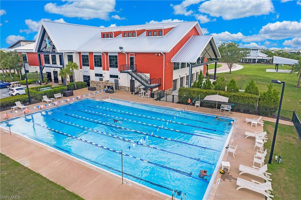 Aerial of the Lee Health Healthy Life Center and resort-style lap pool with lane lines and lounge seating.