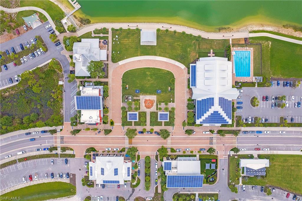 Aerial view of the solar-powered town center with a brick paver main street, lakefront green space, and walkable shops and dining.
