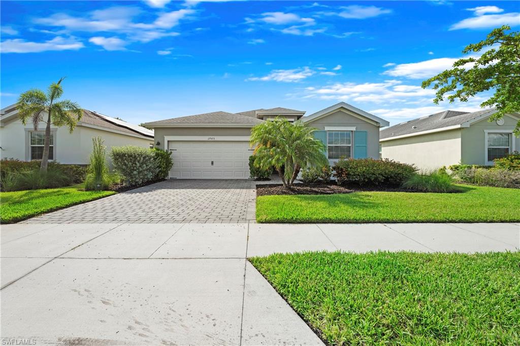 Single-story residence featuring a paver driveway, an attached two-car garage, and a concrete walkway