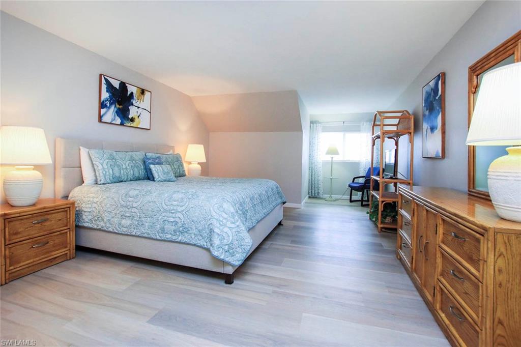 PRIMARY BEDROOM WITH LIGHT WOOD STYLE FLOORING.