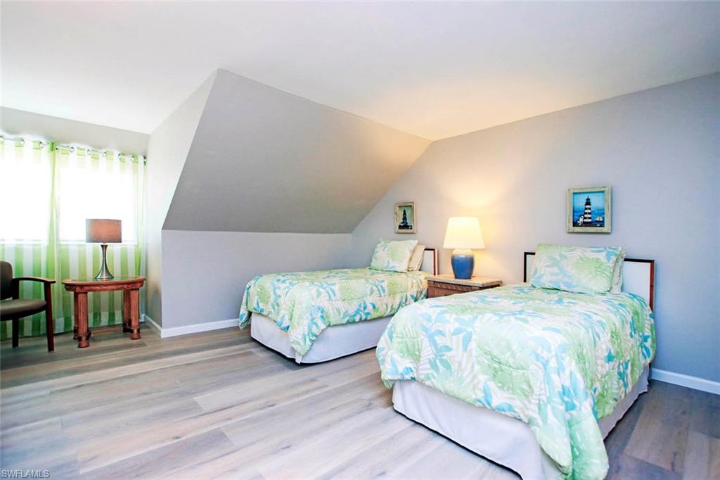 BEDROOM 2 (UPSTAIRS) CHEERFUL ISLAND COLORS, LIGHT WOOD STYLE FLOORING AND COZY READING AREA.