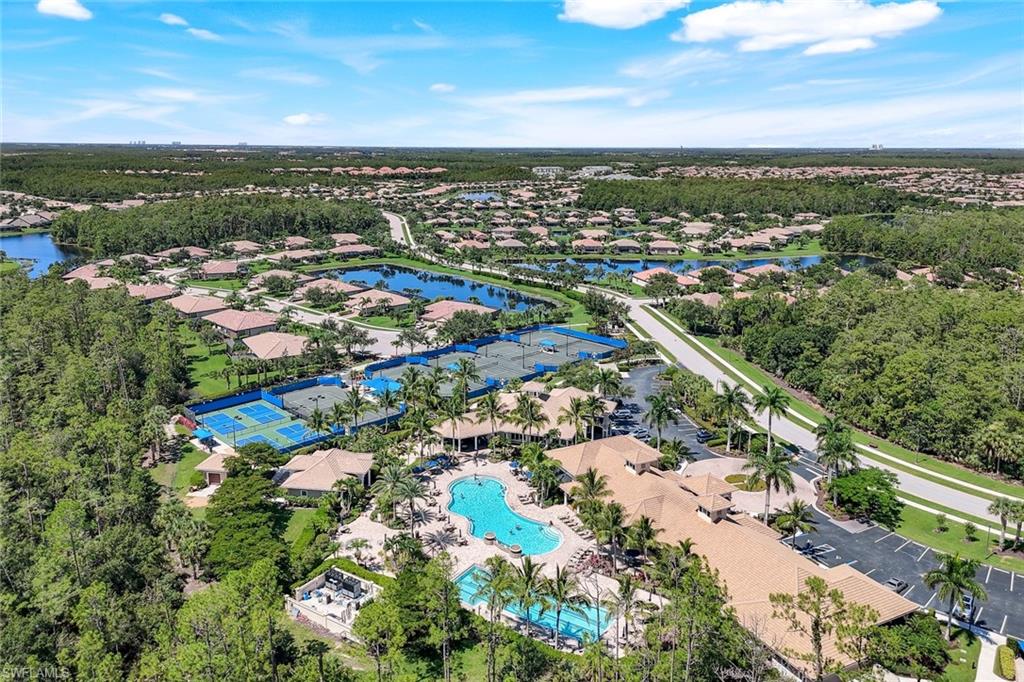 Expansive community featuring multiple lakes, tennis courts, and a large central pool with surrounding structures