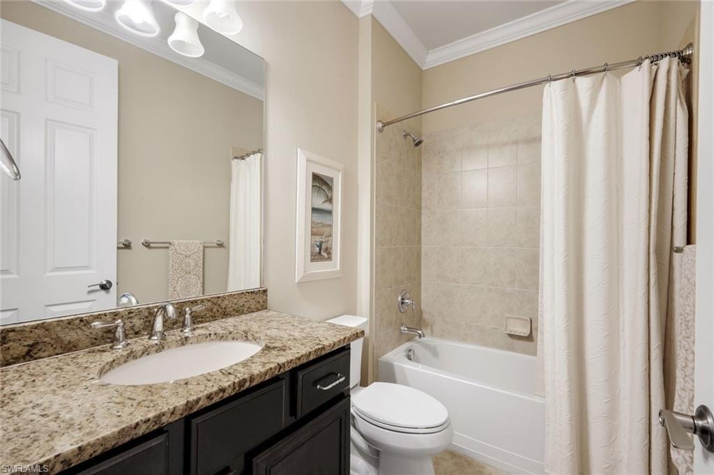 Bathroom featuring a built-in vanity with a stone countertop and undermount sink, brushed nickel fixtures, a full-width mirror, and a tiled shower/tub combination