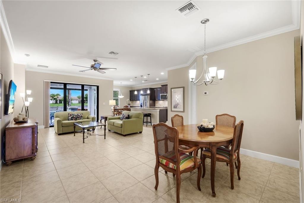 Tile flooring, crown molding, sliding glass doors, ceiling fan, and recessed lighting
