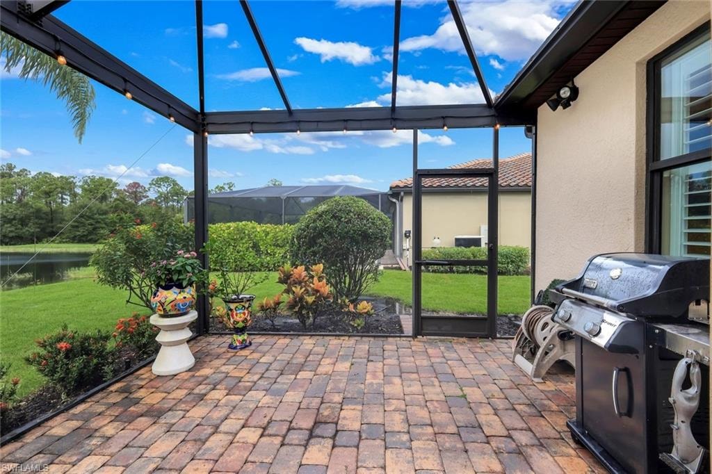 Screened lanai featuring paver flooring, track lighting, and stucco exterior