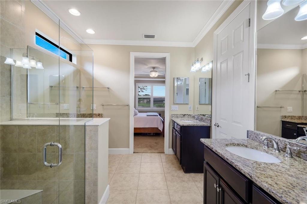Dual vanity with granite countertops, tile flooring, glass-enclosed shower, transom window, and recessed lighting