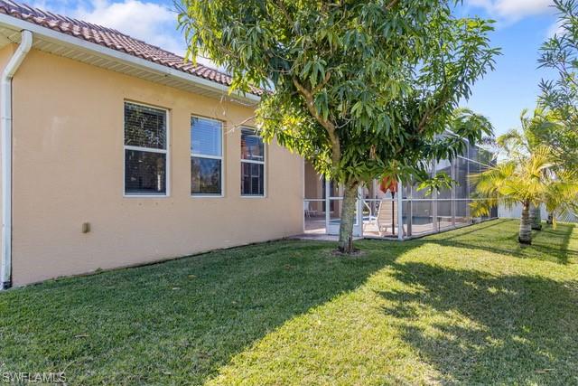 Spacious backyard with a screened patio, mature trees, and lush green lawn