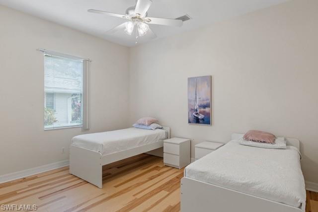 Bedroom featuring wood-finish flooring, a ceiling fan with integrated lighting, and neutral wall tones