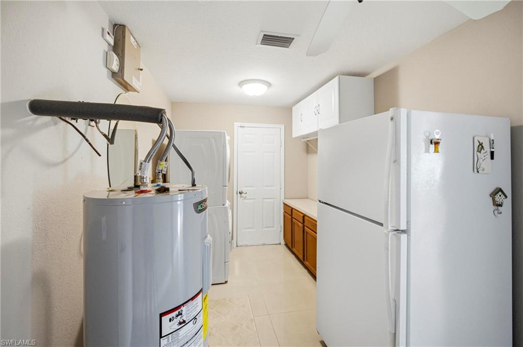 Laundry room features second fridge, additional storage and exit to the side of the house.