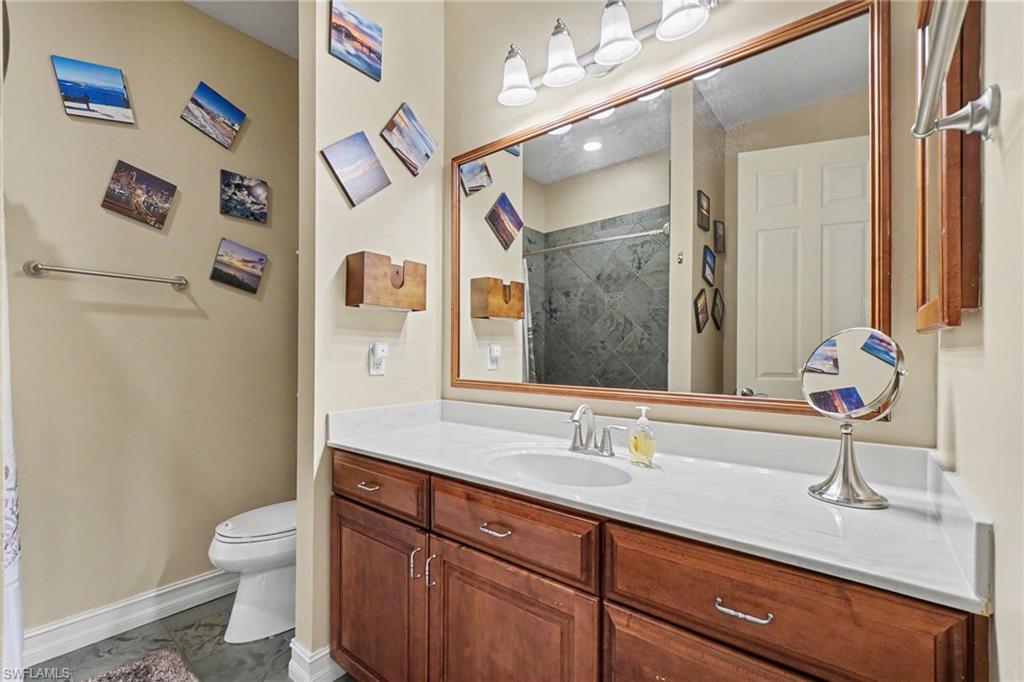 Bathroom featuring a wood-finish vanity with a white countertop and integrated sink