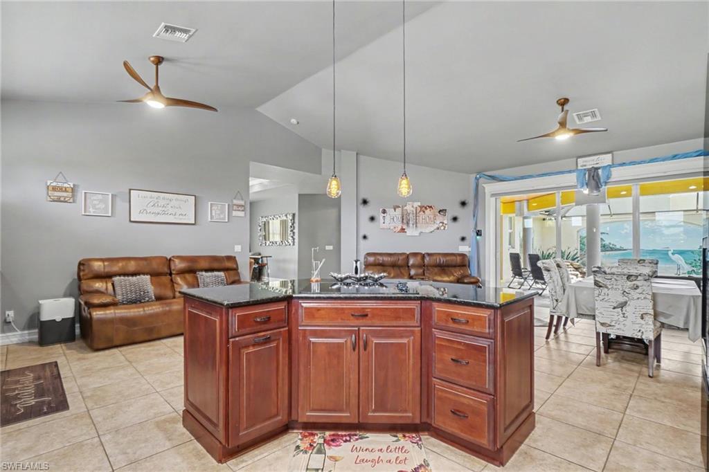Central kitchen island featuring rich wood cabinetry and a dark stone countertop