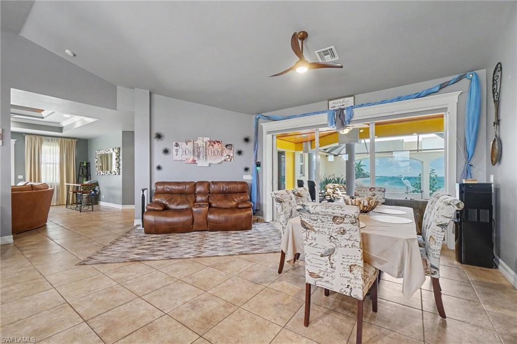 Spacious kitchen and entertaining area featuring a large center island, recessed lighting, tile flooring, and vaulted ceilings
