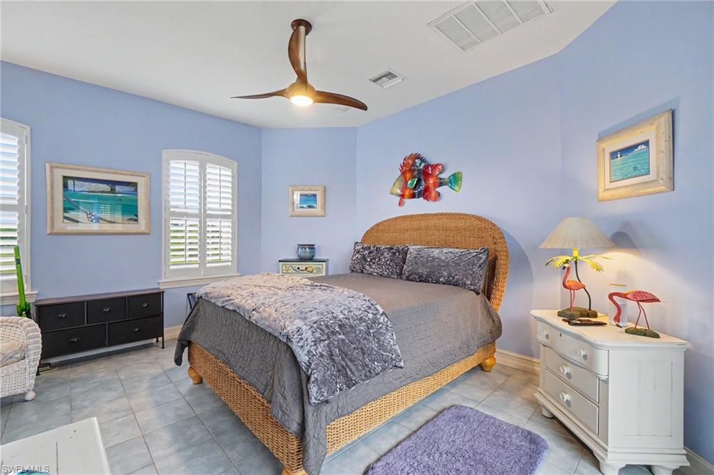 Spacious room featuring multiple windows with plantation shutters, a contemporary ceiling fan with integrated lighting, and tile flooring