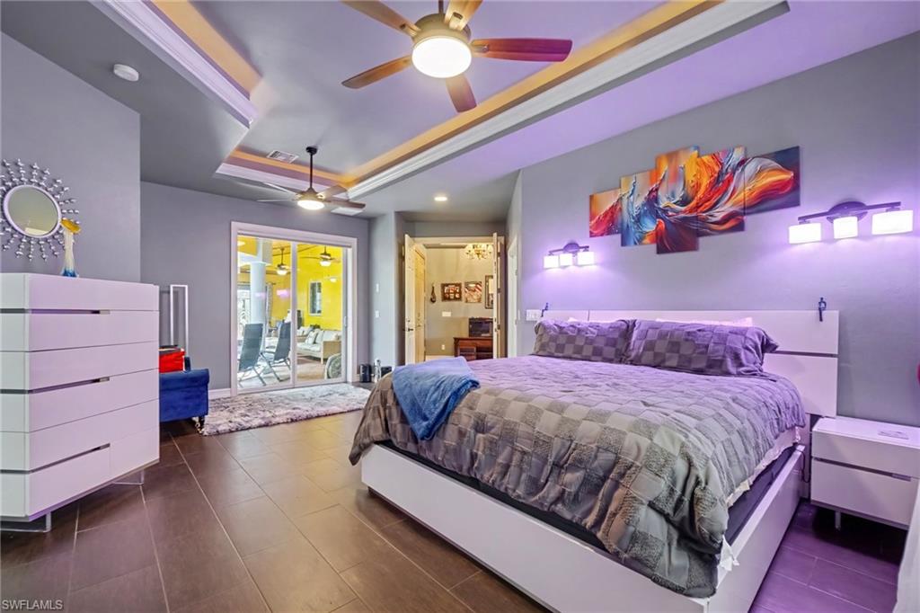 Spacious interior featuring wood-finish flooring, a tray ceiling with integrated lighting, and dual ceiling fans