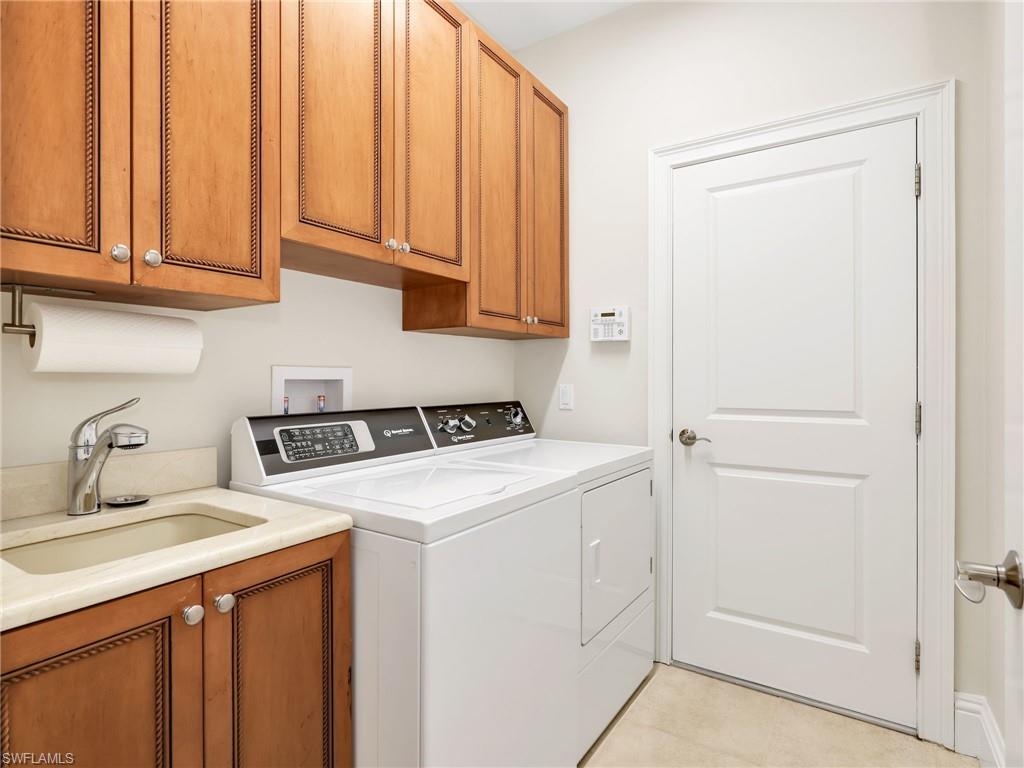 Indoor laundry with sink and cabinets