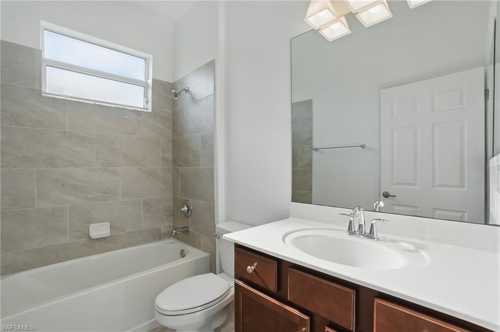 Guest Bathroom featuring a vanity with dark wood-finish cabinetry, a white countertop, and an integrated sink