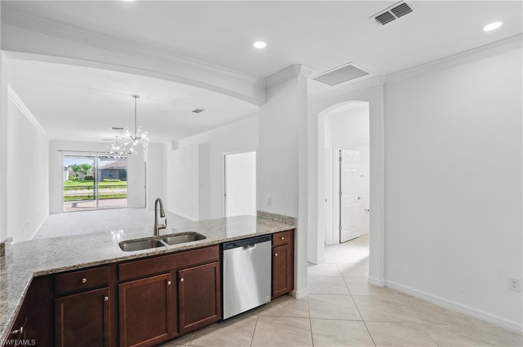 Kitchen island featuring a double-basin sink and stainless steel dishwasher