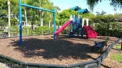 Dedicated play area featuring a multi-level structure with dual slides, climbing features, and a spacious rubberized safety surface