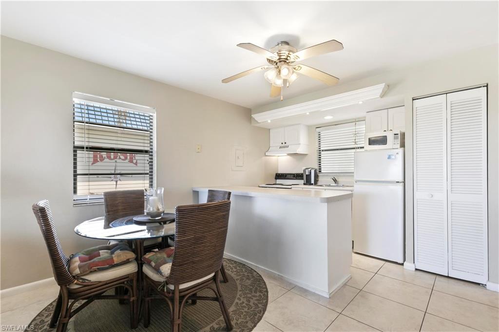 Dining room with sink, ceiling fan, and light tile floors