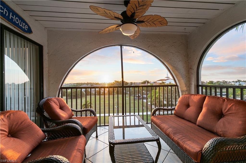 Patio terrace at dusk with an outdoor living space, a balcony, and ceiling fan