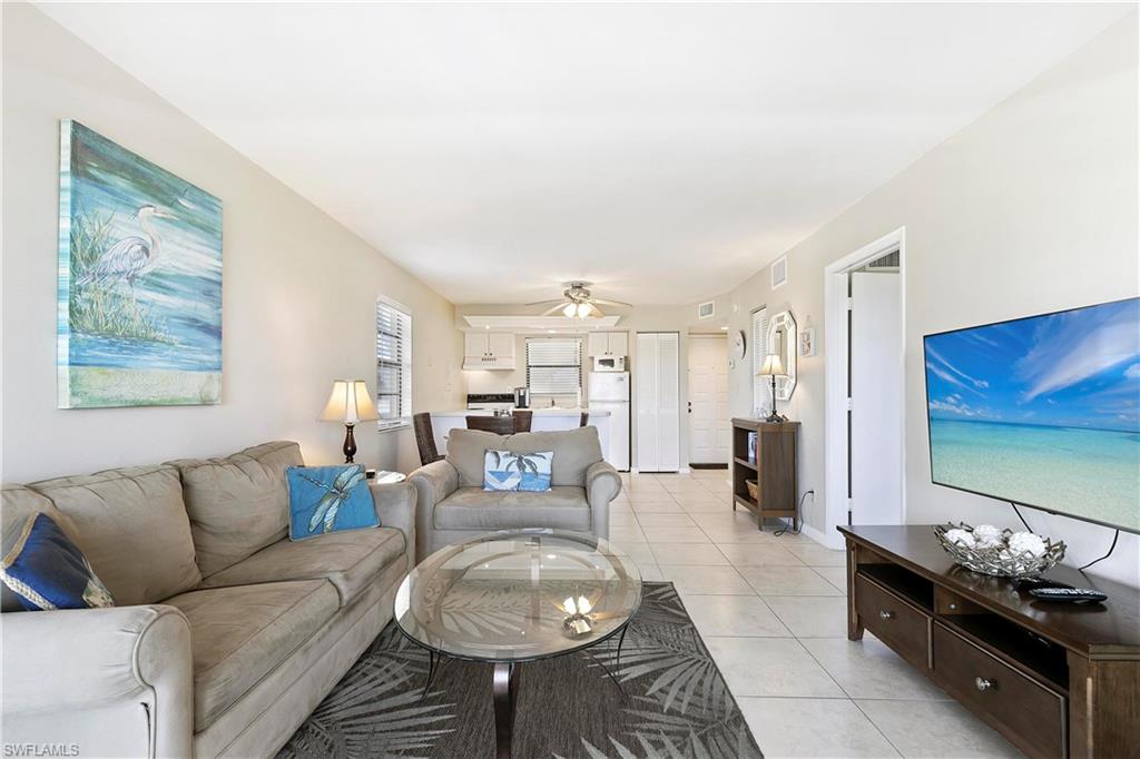 Living room with ceiling fan and light tile flooring