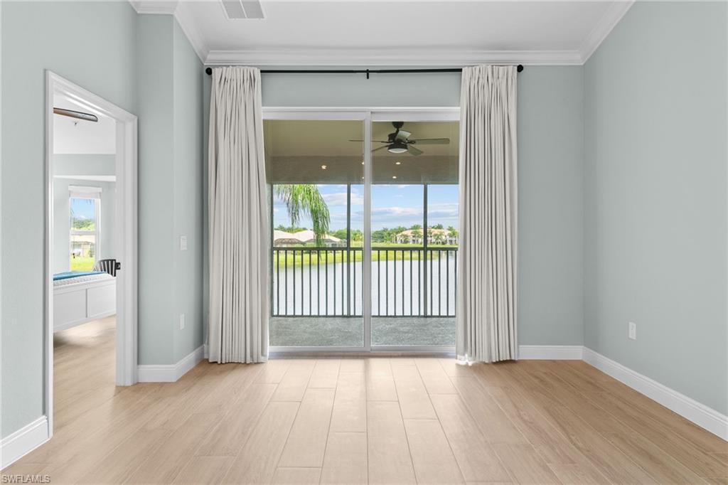 Hurricane impact sliding glass doors open to the screened lanai. View of long part of lake. New window coverings added for privacy and energy efficiency. Lanai is covered/protected with a ceiling fan.