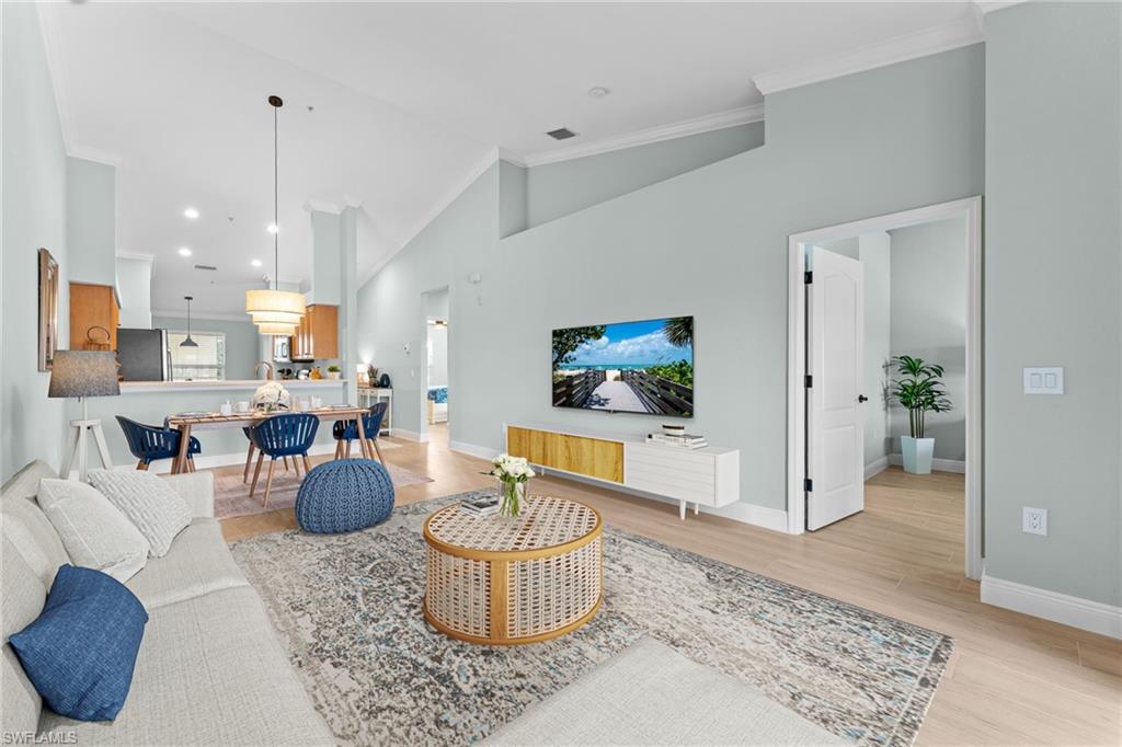 Partially Virtually Staged. Gorgeous wood oak plank tiles througout with 5 1/4" baseboards. Soaring cathedral ceilings, crown molding, professionally painted - ALL combine for an elevated, updated condo!. Opens to primary bedroom.
