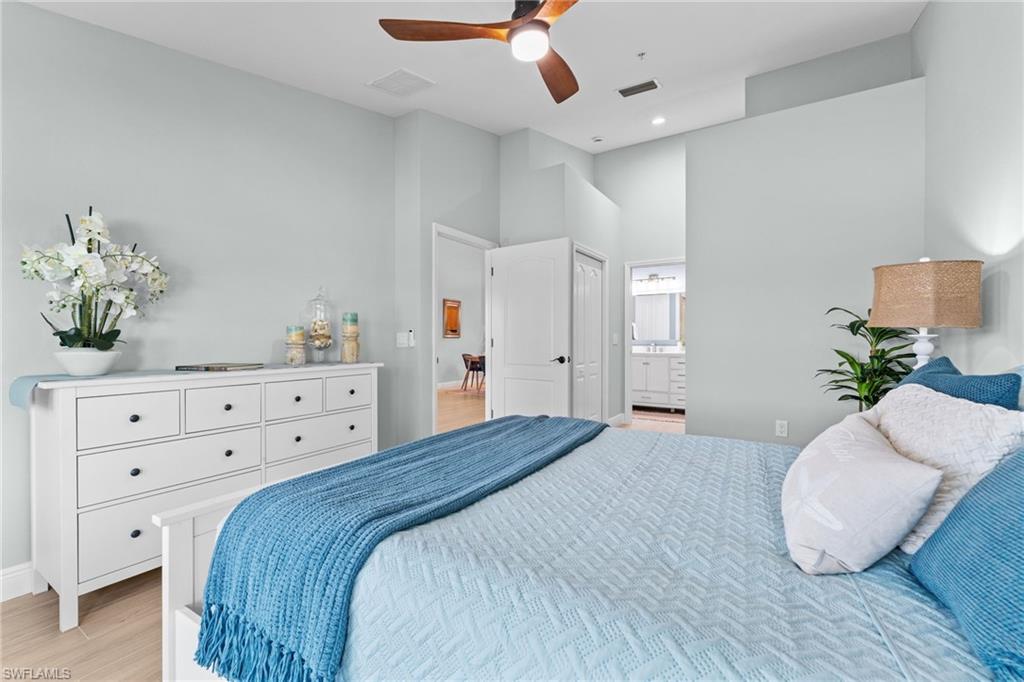 View of bedroom, door to main living area, hallway to primary bathroom with 2 closets - 1 on each side.