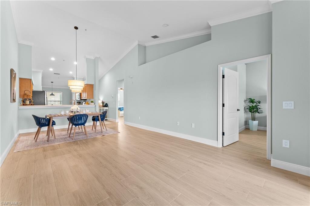 Gorgeous wood ook plank tiles througout with 5 1/4" baseboards. Soaring cathedral ceilings, crown molding, professionally painted - ALL combine for an elevated, updated condo!. Opens to primary bedroom.