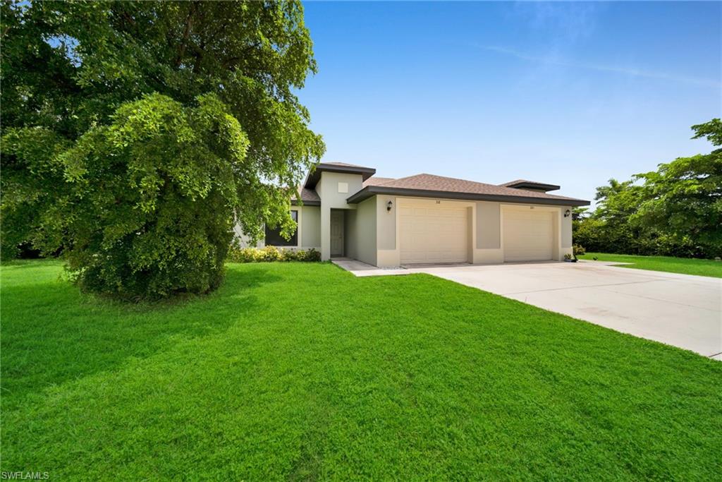Contemporary single-story residence featuring a neutral-toned stucco exterior, a brown shingle roof, and a two-car garage with light-colored doors