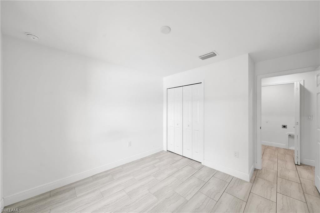 White-painted interior space featuring tile flooring with a light grey wood-finish pattern
