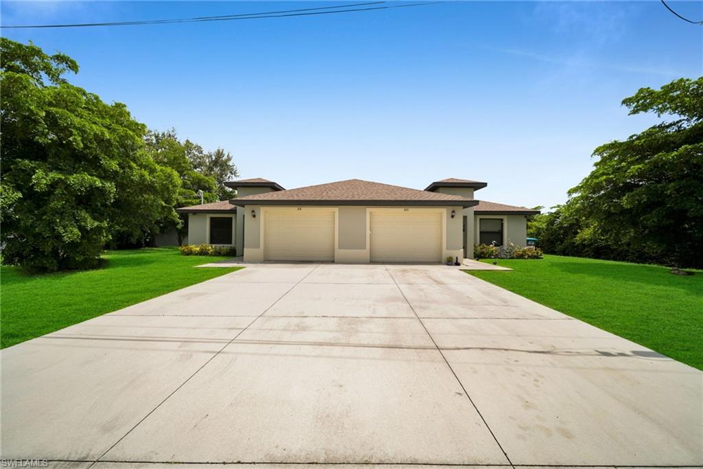 Duplex property featuring a stucco exterior and a brown shingle roof