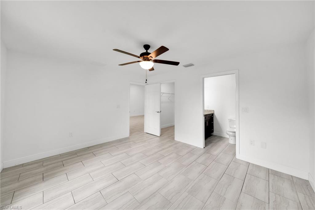 Bright, open living space featuring light wood-finish flooring throughout, recessed lighting, and a ceiling fan with integrated light fixture