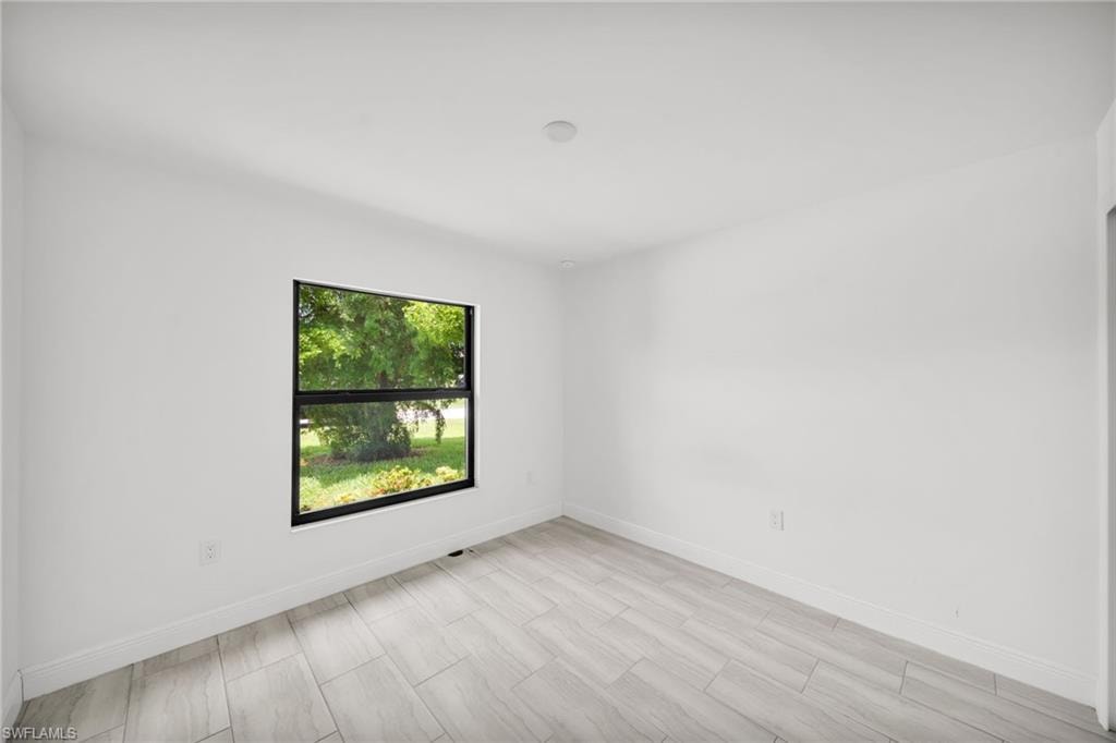 Room featuring light-toned tile flooring and a black-framed window