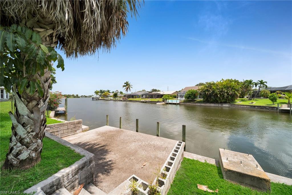 Waterfront property featuring a concrete dock, seawall, and access to a navigable canal
