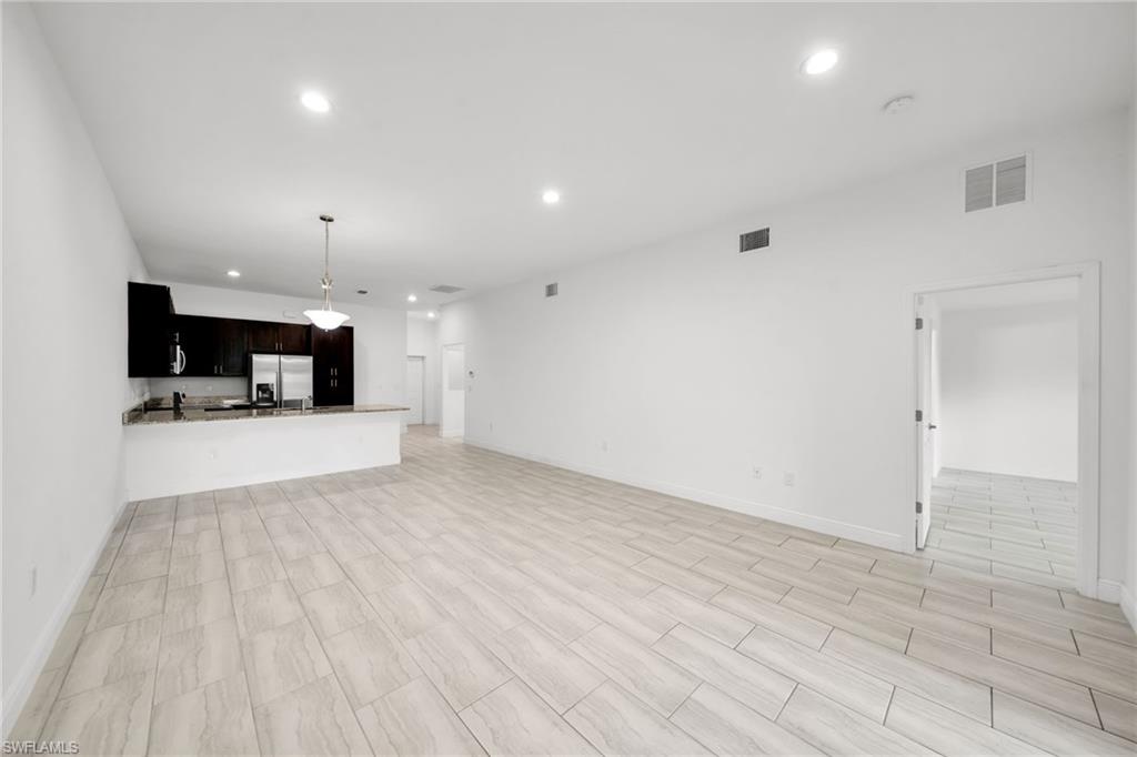 Open-concept living space featuring wood-finish tile flooring and recessed lighting