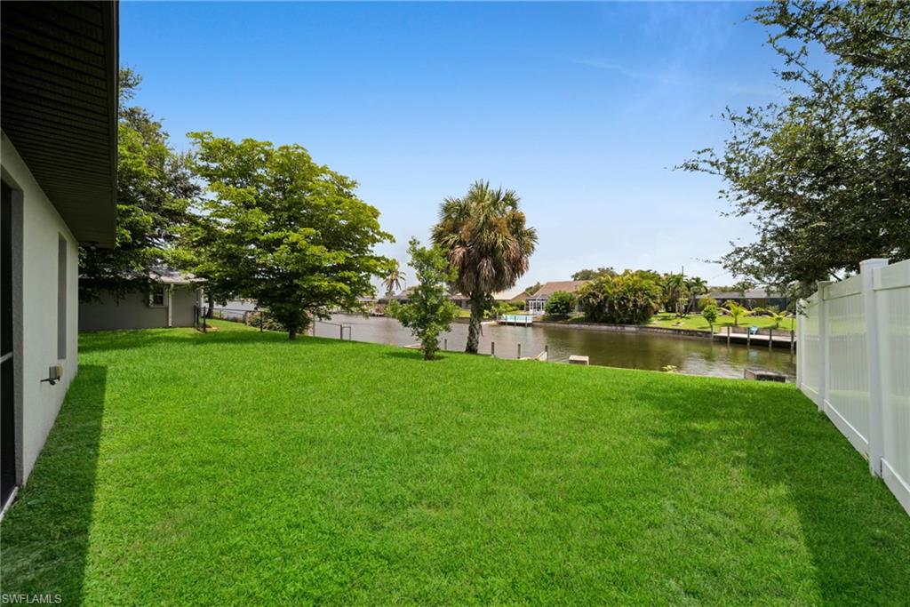 Expansive green lawn extending to a waterfront canal